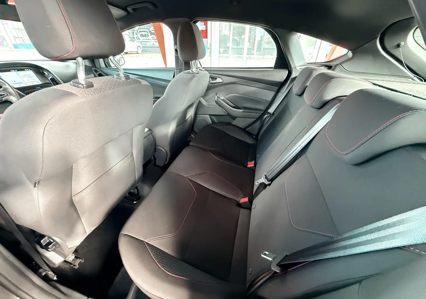 Vue rapprochée de l'écran tactile central du Ford Focus gris, affichant la navigation et les options multimédia.