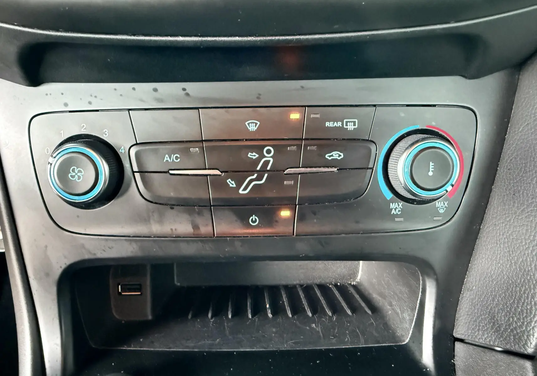 Gros plan sur les commandes de lève-vitres et réglage des rétroviseurs côté conducteur d'une Ford Focus gris 2018.