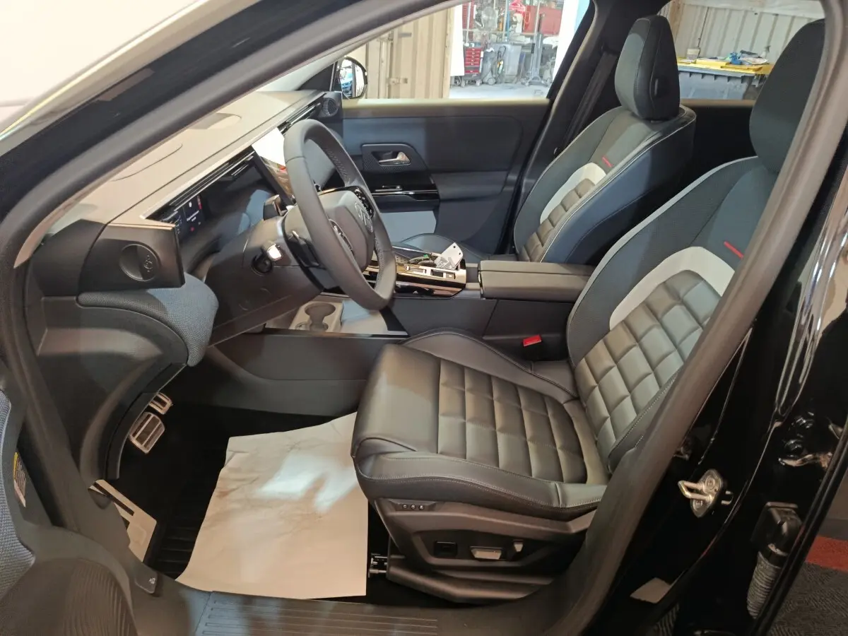 Intérieur avant droit du Citroën C5 Hybride noir 2026, sièges cuir noir et tableau de bord moderne avec écran tactile.