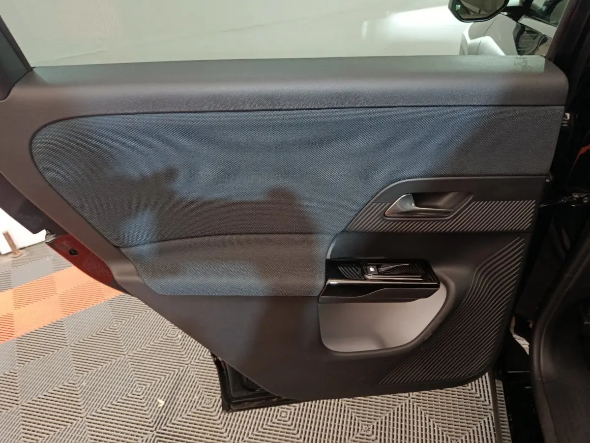 Vue intérieure côté gauche de la porte arrière noire du Citroën C5 Hybride 2026 avec insert texturé et poignée argentée.