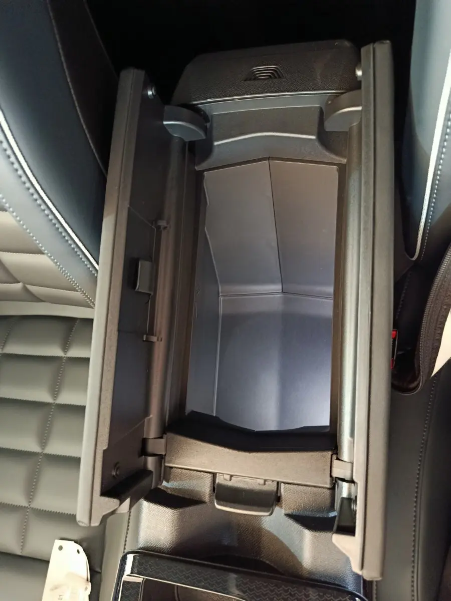 Vue plongeante sur le rangement central ouvert avec intérieur noir et sellerie cuir noir matelassée de la Citroën C5 Hybride.