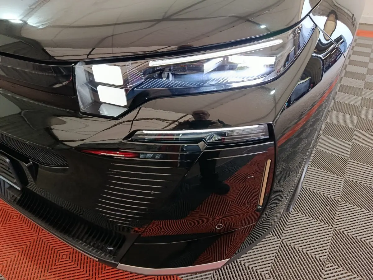 Gros plan sur le phare avant droit noir brillant de la Citroën C5 Hybride 2026 avec éclairage LED distinctif.