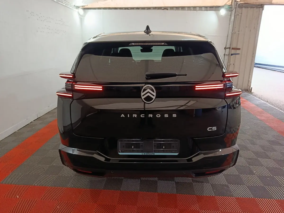 Vue arrière d'une Citroën C5 Aircross noire avec feux LED allumés dans un garage fermé.