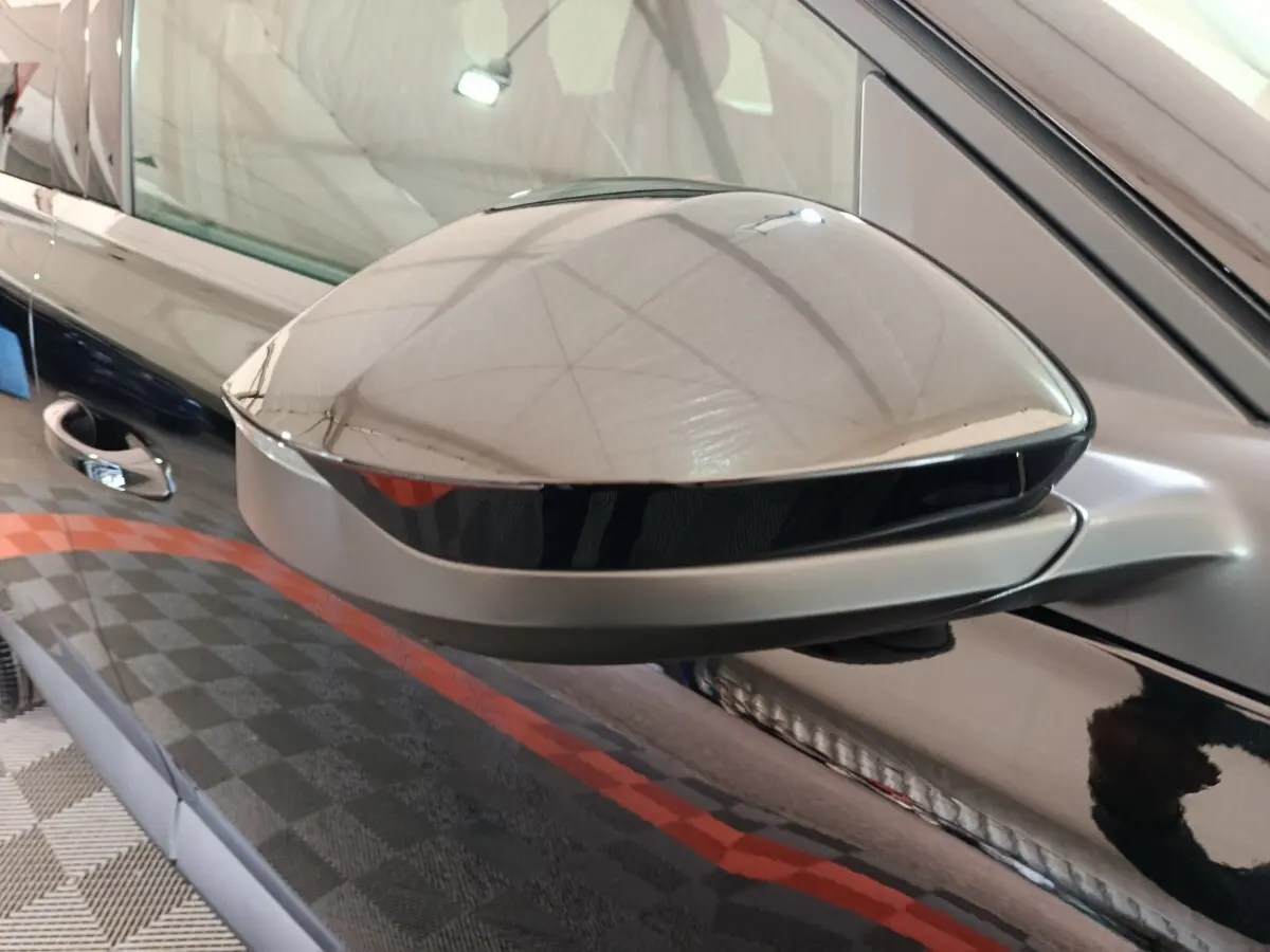 Rétroviseur côté gauche noir brillant de Citroën C5 Hybride 2026 avec carrosserie noire réfléchissante.