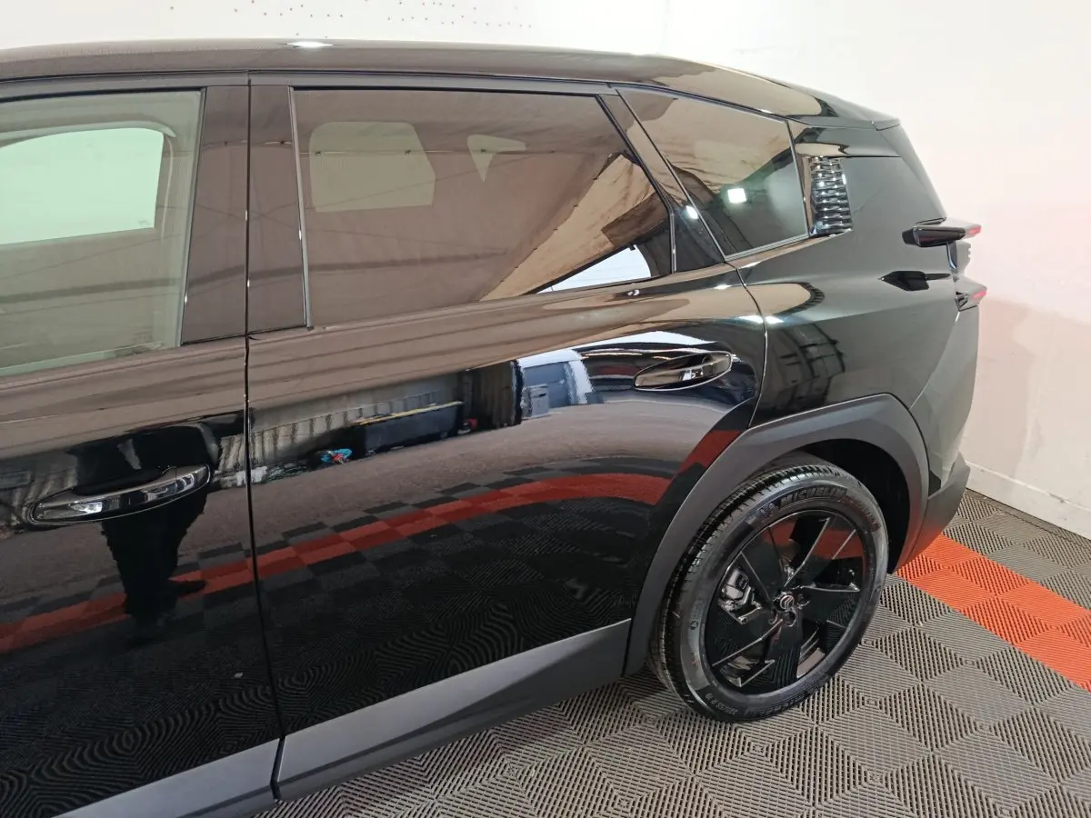 Vue côté droit arrière du Citroën C5 Hybride noir, mettant en valeur la roue et les lignes latérales lisses.