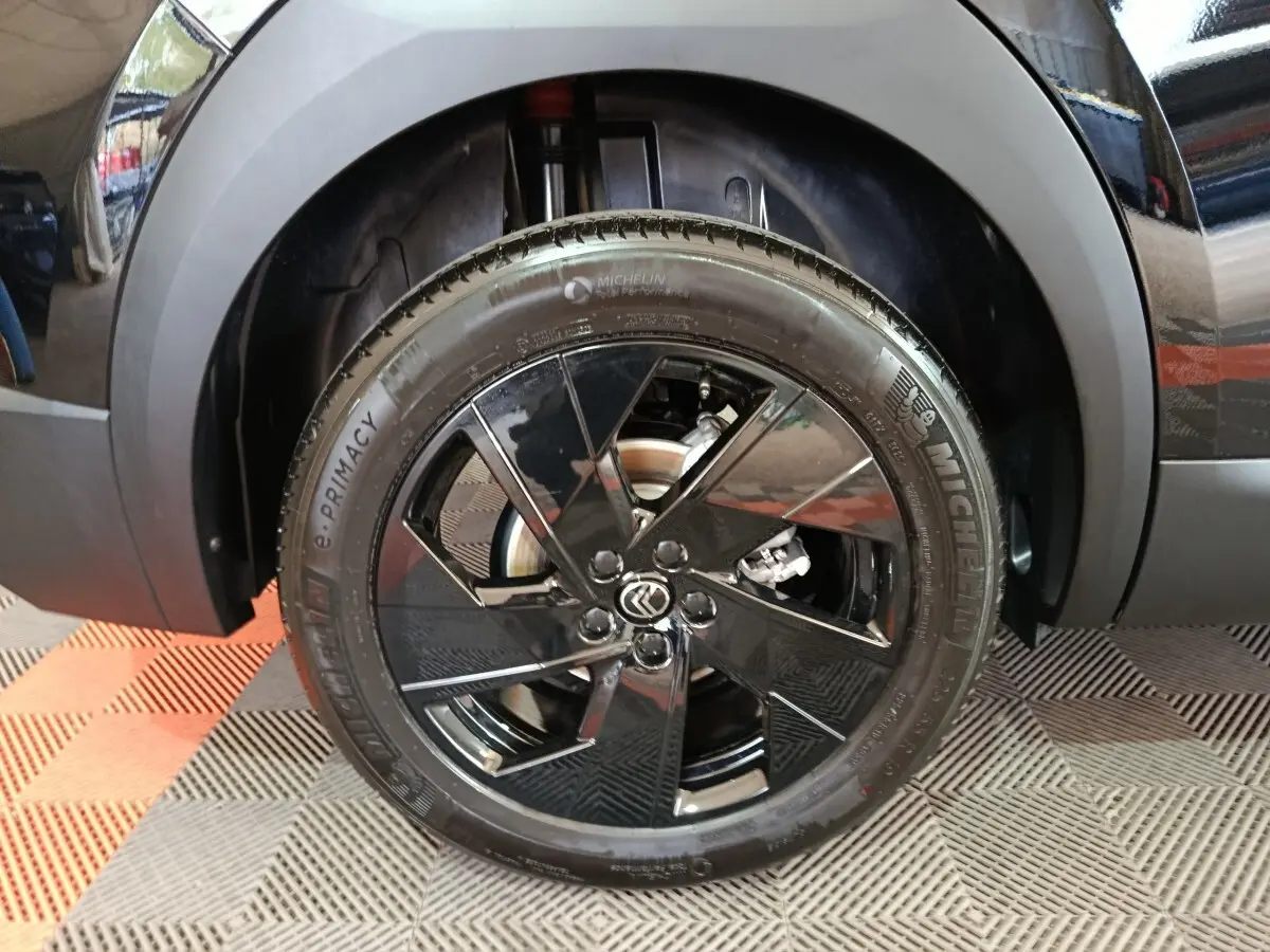Gros plan sur la roue avant gauche noire brillante d’une Citroën C5 Hybride 2026 avec jante au design moderne.