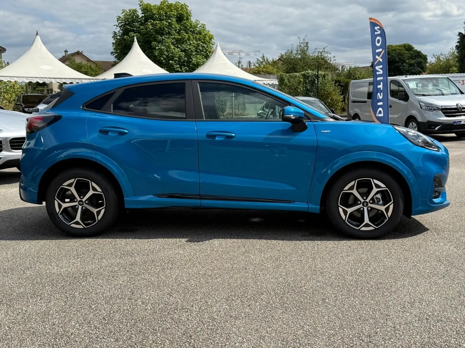 Profil côté gauche du Ford Puma 2025 bleu Aqua Blue avec jantes alliage et lignes sportives ST Line visibles.