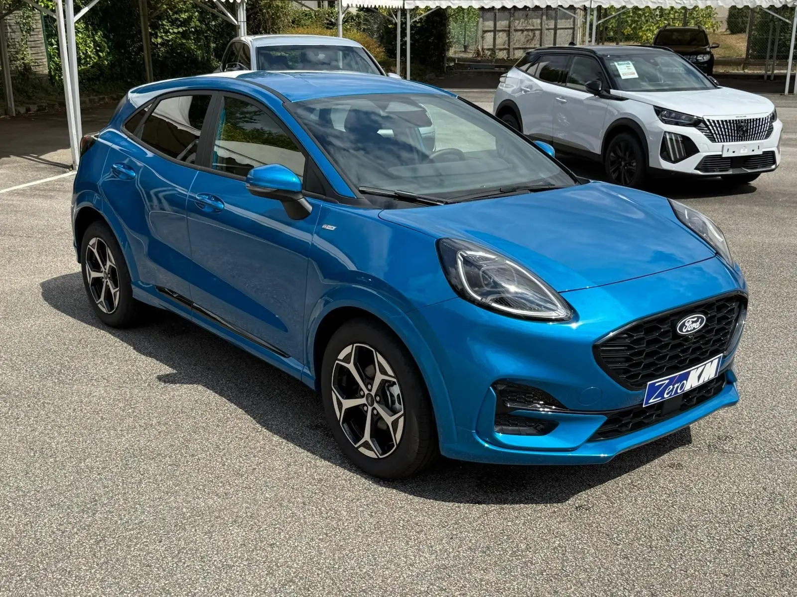 Ford Puma 2025 bleu Aqua Blue en 3/4 avant droit, avec jantes alliage et calandre noire distinctive.
