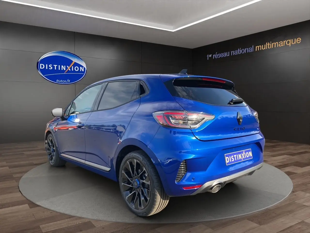 Vue 3/4 arrière droite d'une Renault Clio V TCE 90 Esprit Alpine bleu Iron avec jantes noires et échappement chromé.