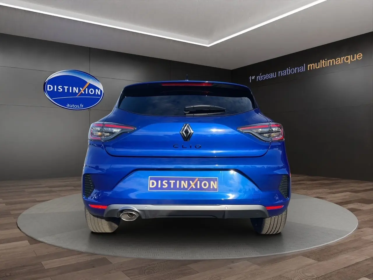 Vue arrière d'une Renault Clio V TCE 90 Esprit Alpine bleu Iron avec échappement visible en concession.