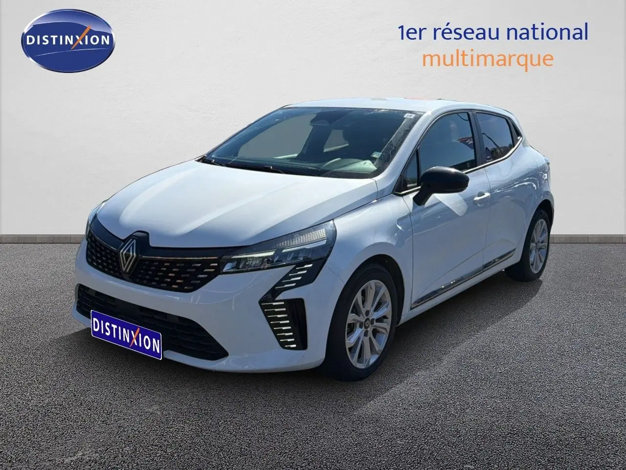 Renault Clio blanche vue 3/4 avant droit, avec calandre noire et feux LED distinctifs, sur fond neutre.