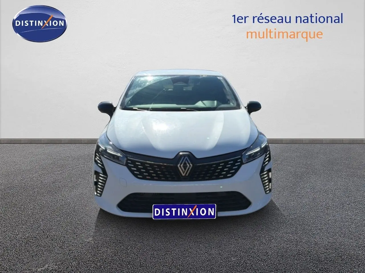 Vue avant d'une Renault Clio blanche 2025 avec calandre noire et feux LED verticaux allumés.