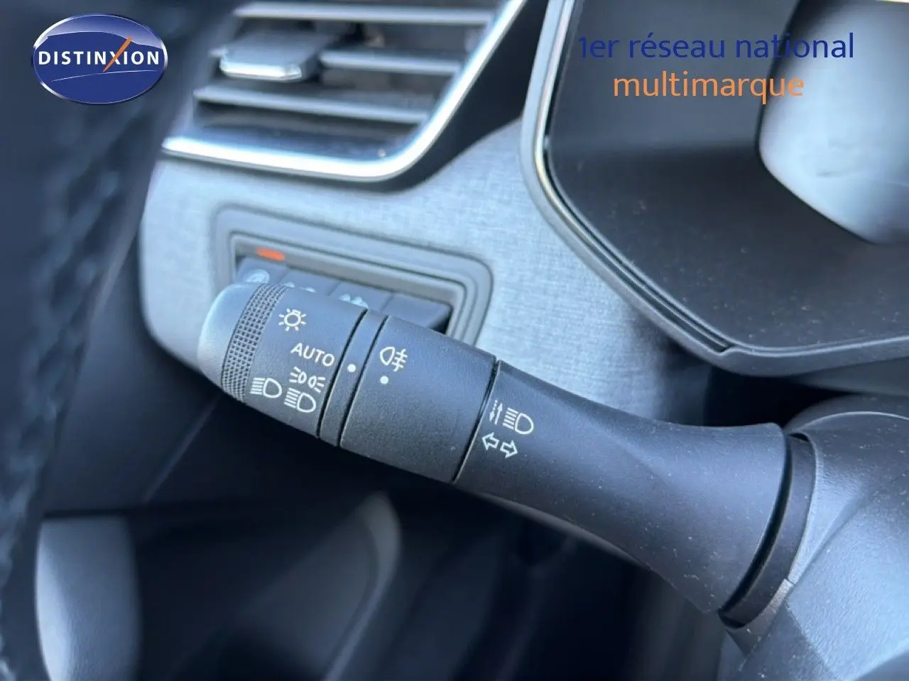 Gros plan sur la commande des phares et clignotants dans l’habitacle d’une Renault Clio blanche 2025.