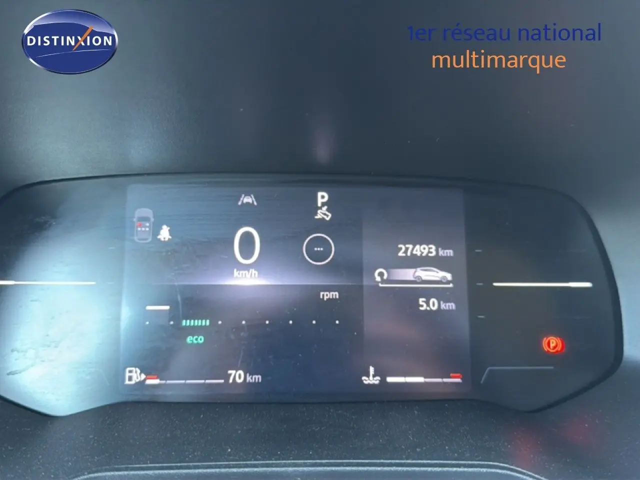 Tableau de bord numérique de Renault Clio blanc 2025 affichant 27 493 km et indicateurs de vitesse et carburant.