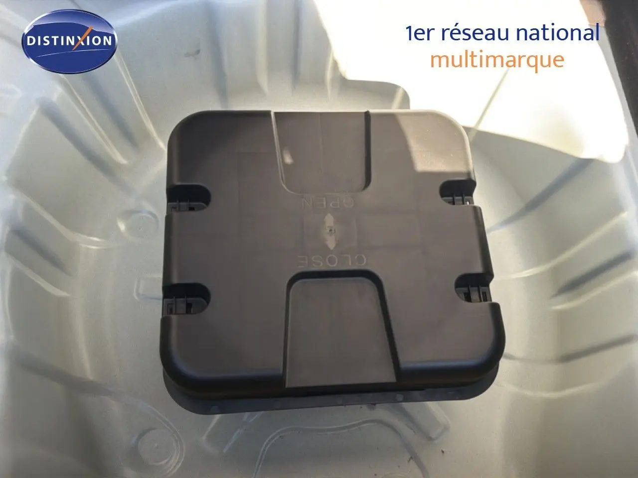 Vue rapprochée du coffre à outils noir dans le compartiment de roue de secours d'une Renault Clio blanche.