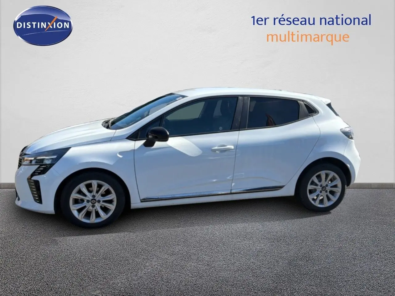 Profil droit d'une Renault Clio blanche 2025 avec jantes alliage et rétroviseurs noirs, sur fond neutre.