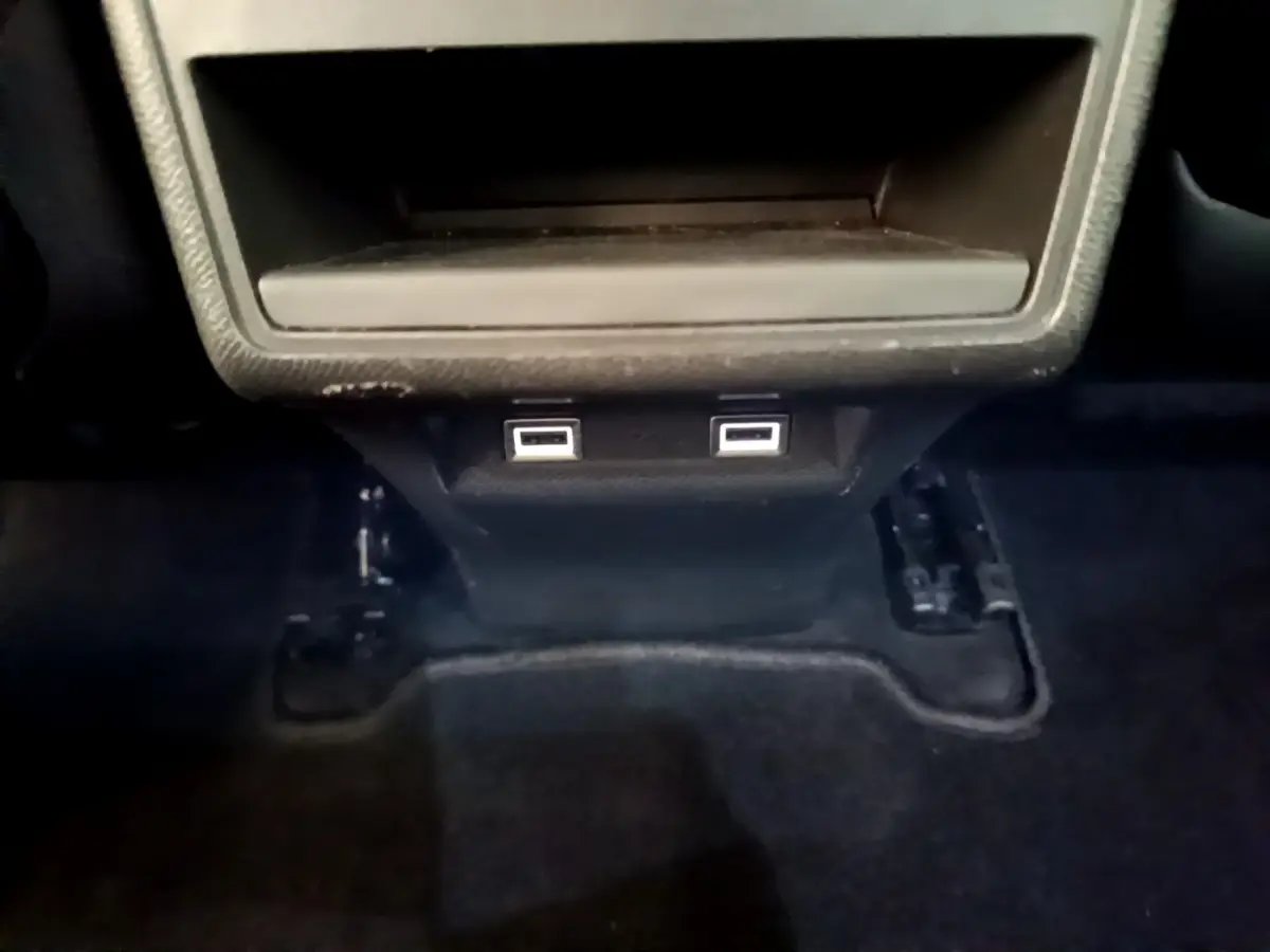 Gros plan sur les ports USB arrière noirs du DS7 Crossback gris foncé, sous la console centrale.