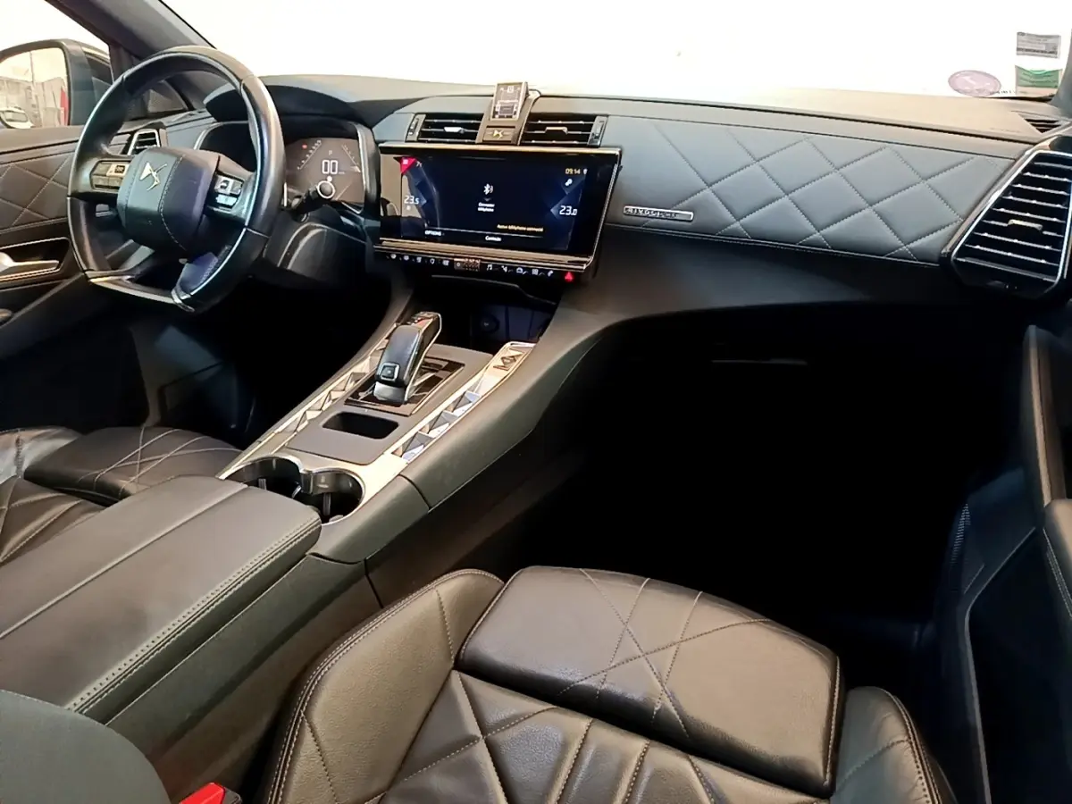 Vue intérieure côté passager du tableau de bord et console centrale en cuir noir matelassé du DS7 Crossback 2019.