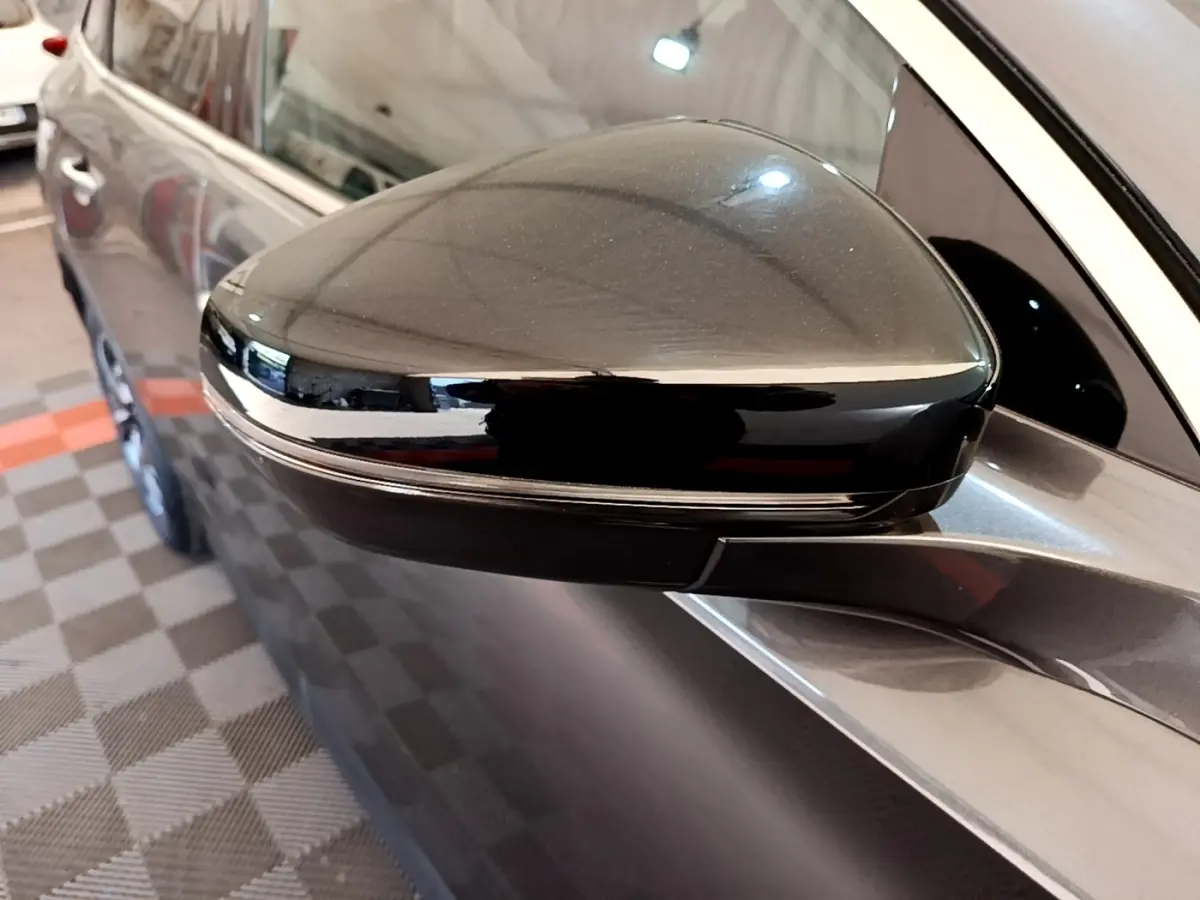 Rétroviseur droit noir brillant d'un DS7 Crossback gris foncé, vue rapprochée sur la porte avant côté droit.