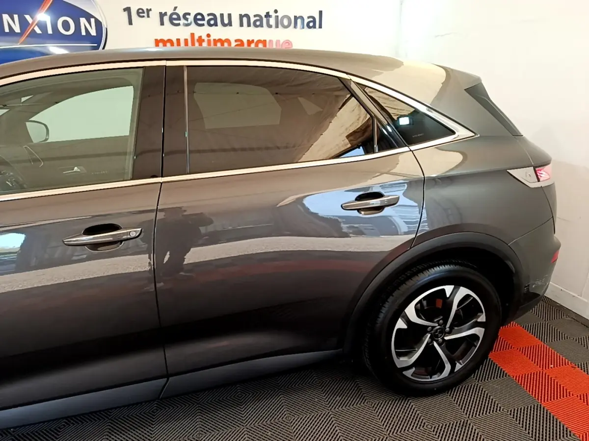 Vue latérale droite du DS7 Crossback gris foncé, mettant en valeur les jantes et la ligne de toit élégante.