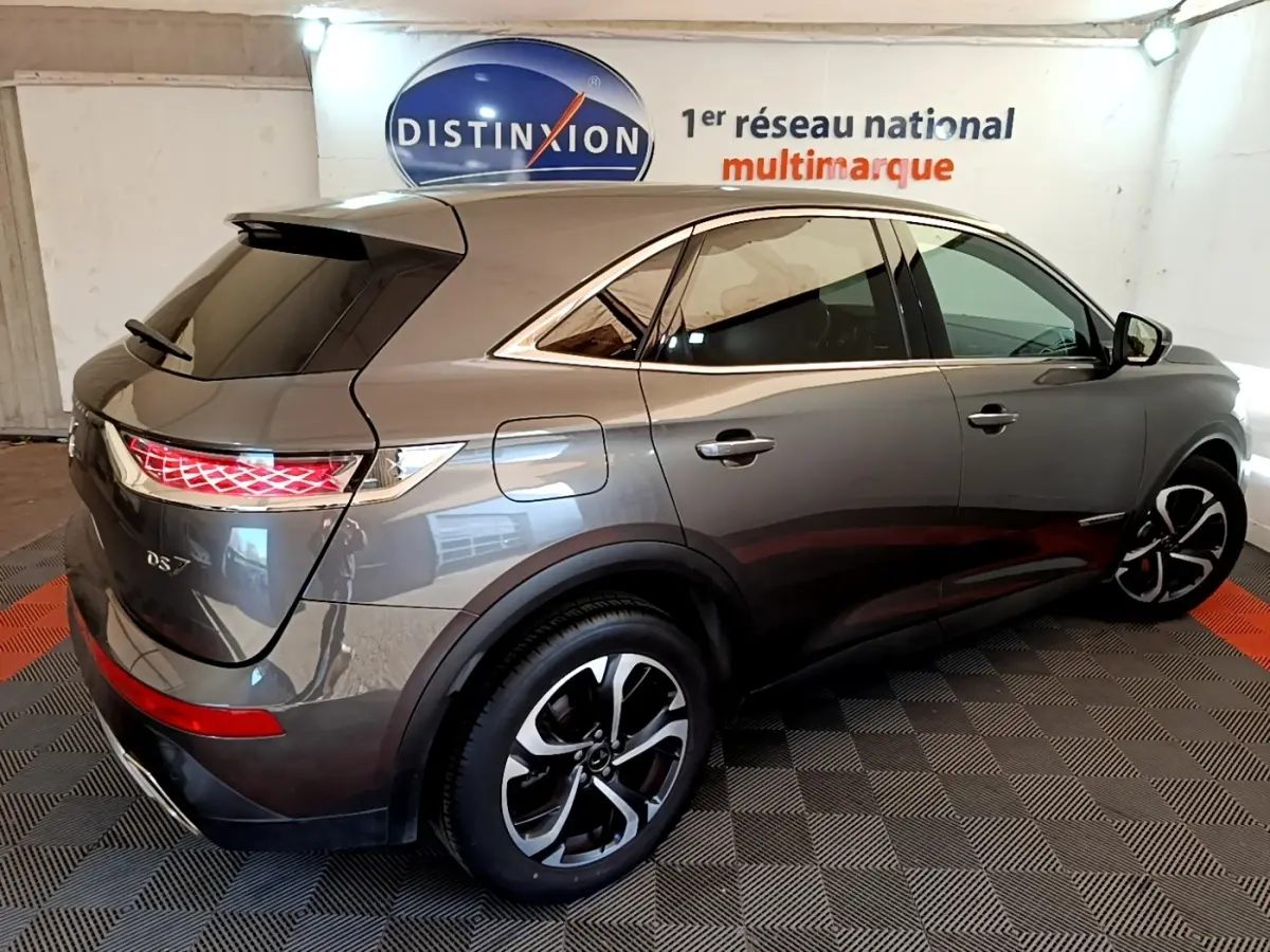 DS7 Crossback gris foncé vu en 3/4 arrière droit, avec feux arrière LED et jantes alliage distinctives.
