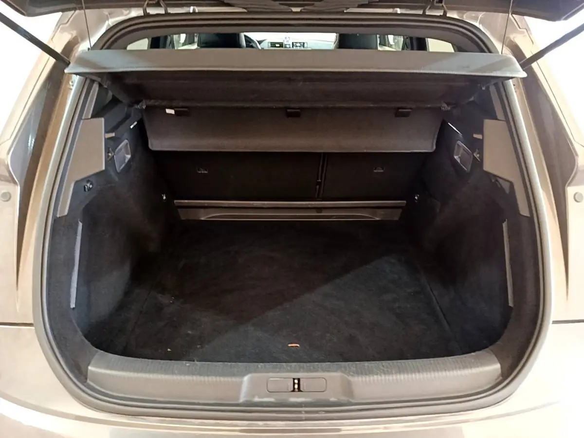 Coffre ouvert vu de l'arrière d'un DS7 Crossback gris foncé, montrant un espace de chargement vide et propre.