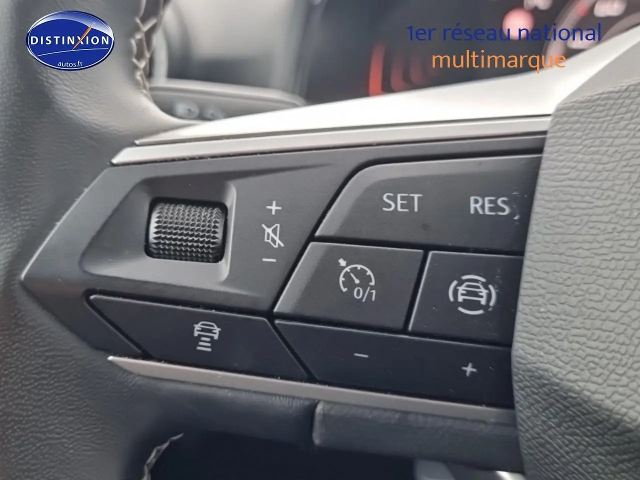 Gros plan sur les commandes du volant cuir multifonction du SEAT Arona gris magnétique, boutons de régulateur de vitesse.