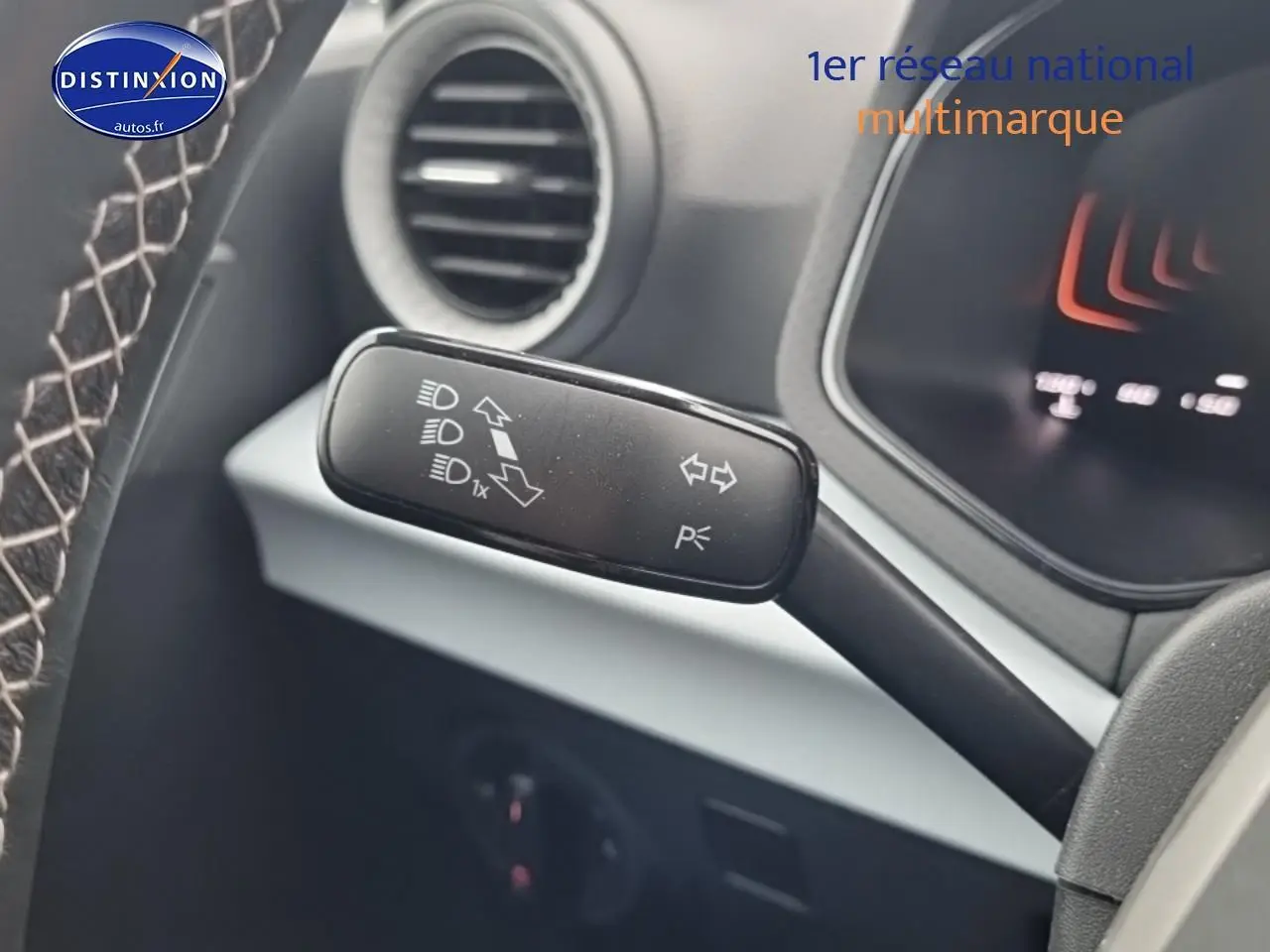 Gros plan sur la manette de clignotant et feux du tableau de bord d’un SEAT Arona gris magnétique 2025.