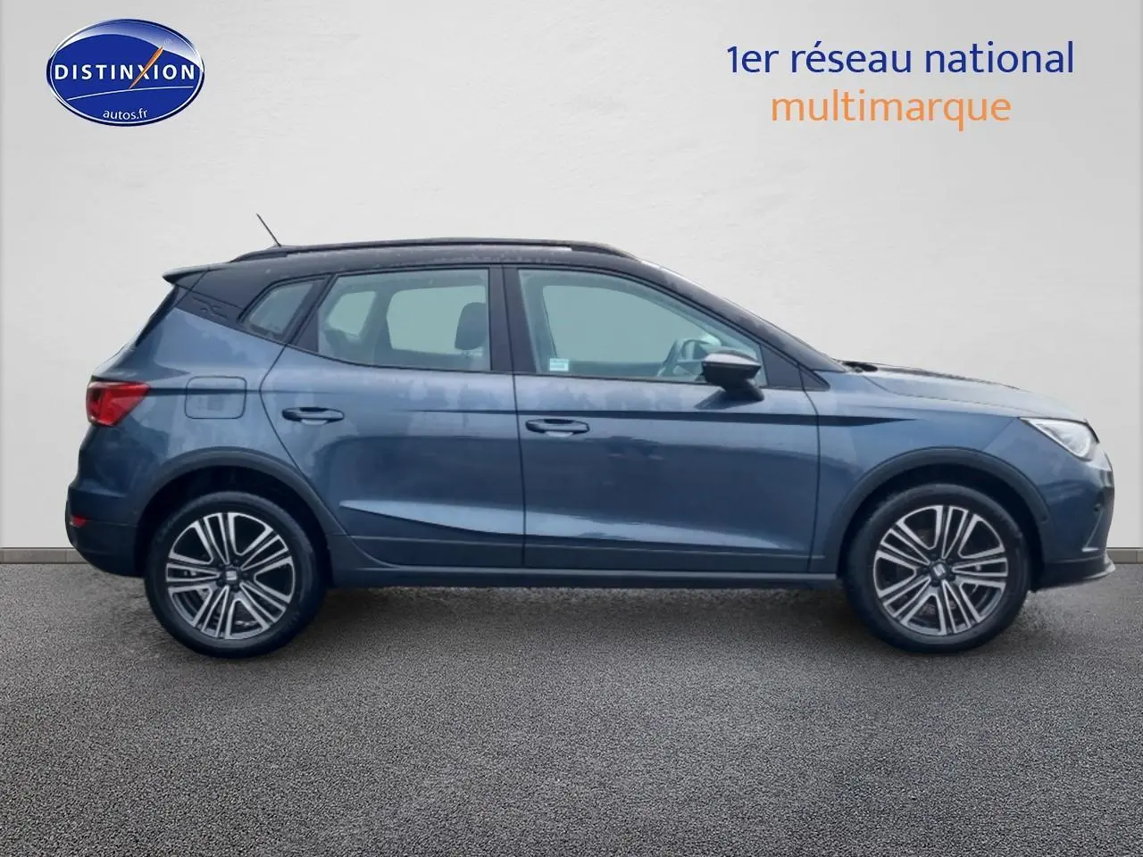 Profil droit d'un SEAT Arona gris magnétique 2025 avec jantes 17 pouces et barres de toit noires.