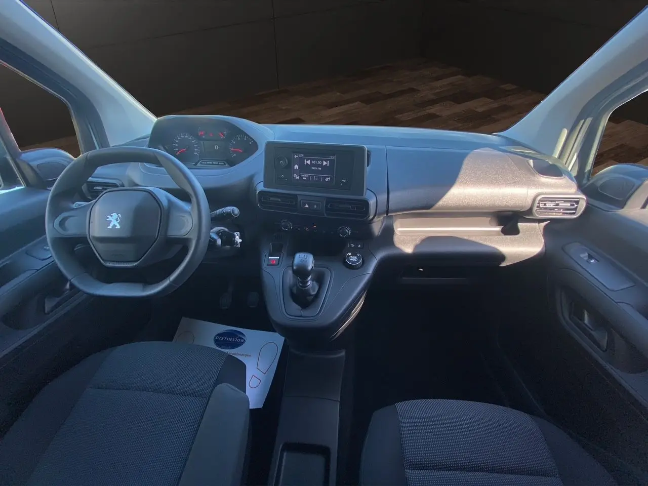 Vue intérieure avant du Peugeot Partner Fourgon Dangel 4x4 2025, tableau de bord et sièges tissu noir visibles.