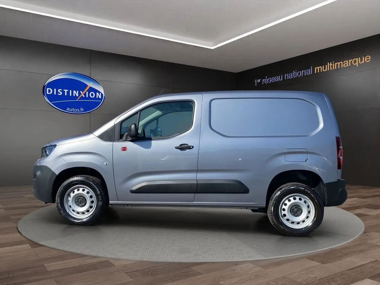 Profil latéral droit du Peugeot Partner Fourgon Dangel 4x4 2025 en gris Artense métallisé avec jantes tôles et logo Dangel sur la porte.