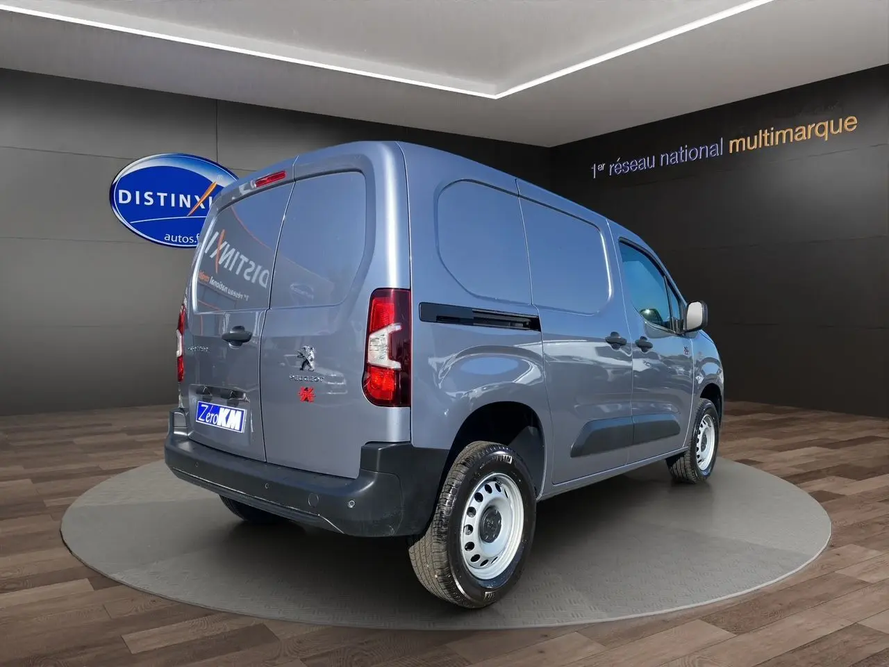 Vue 3/4 arrière droite du Peugeot Partner Fourgon Dangel 4x4 gris Artense métallisé en showroom.