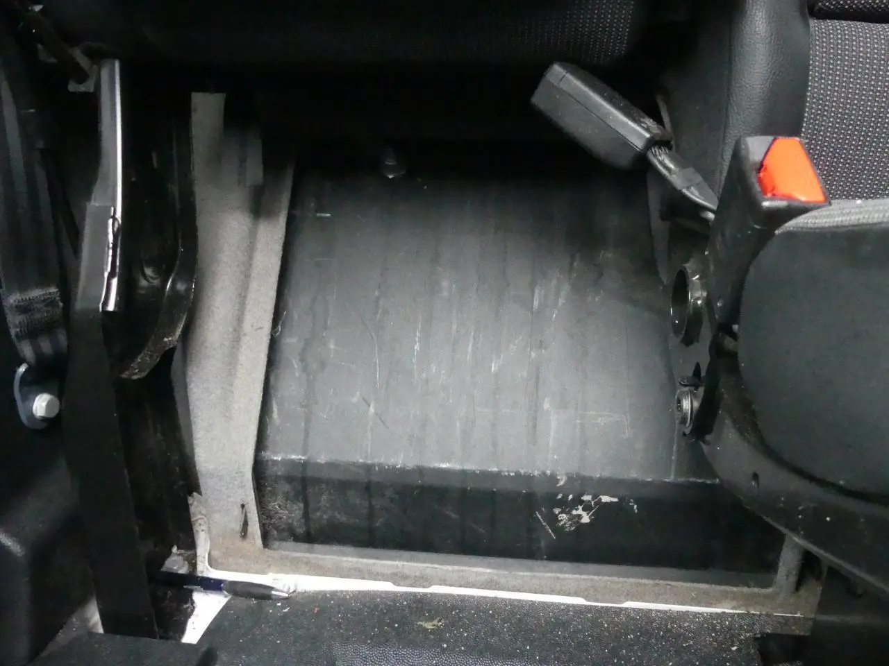 Détail du plancher bois noir et siège avant droit avec ceinture rouge dans le fourgon Peugeot Expert blanc 2019