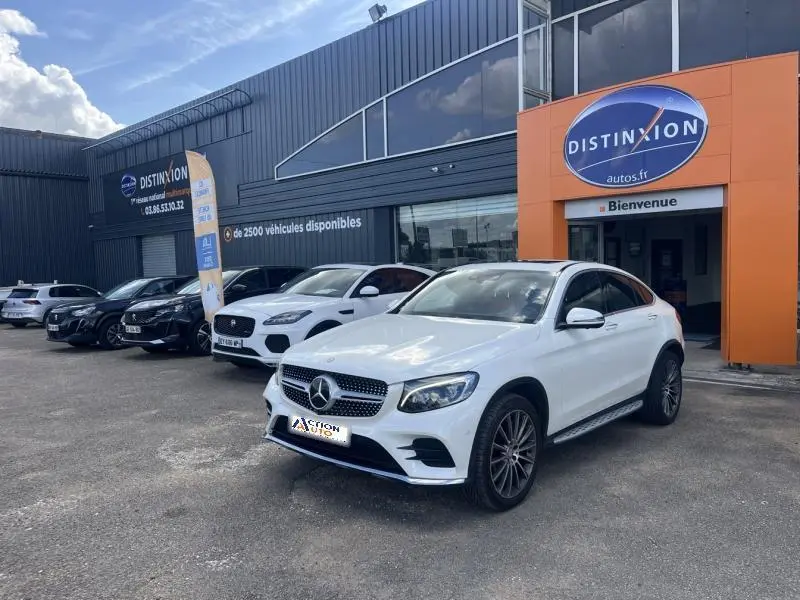 Mercedes GLC Coupé blanc diamant brillant designo vu en 3/4 avant droit devant un concessionnaire Distinxion.