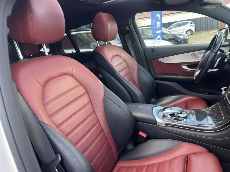 Intérieur de Mercedes GLC Coupé 220 d 2016, sièges sport cuir bicolore rouge et noir vus côté conducteur.