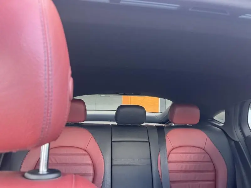 Vue arrière intérieure du Mercedes GLC Coupé 220 d avec sièges sport cuir rouge et noir, toit ouvrant visible.