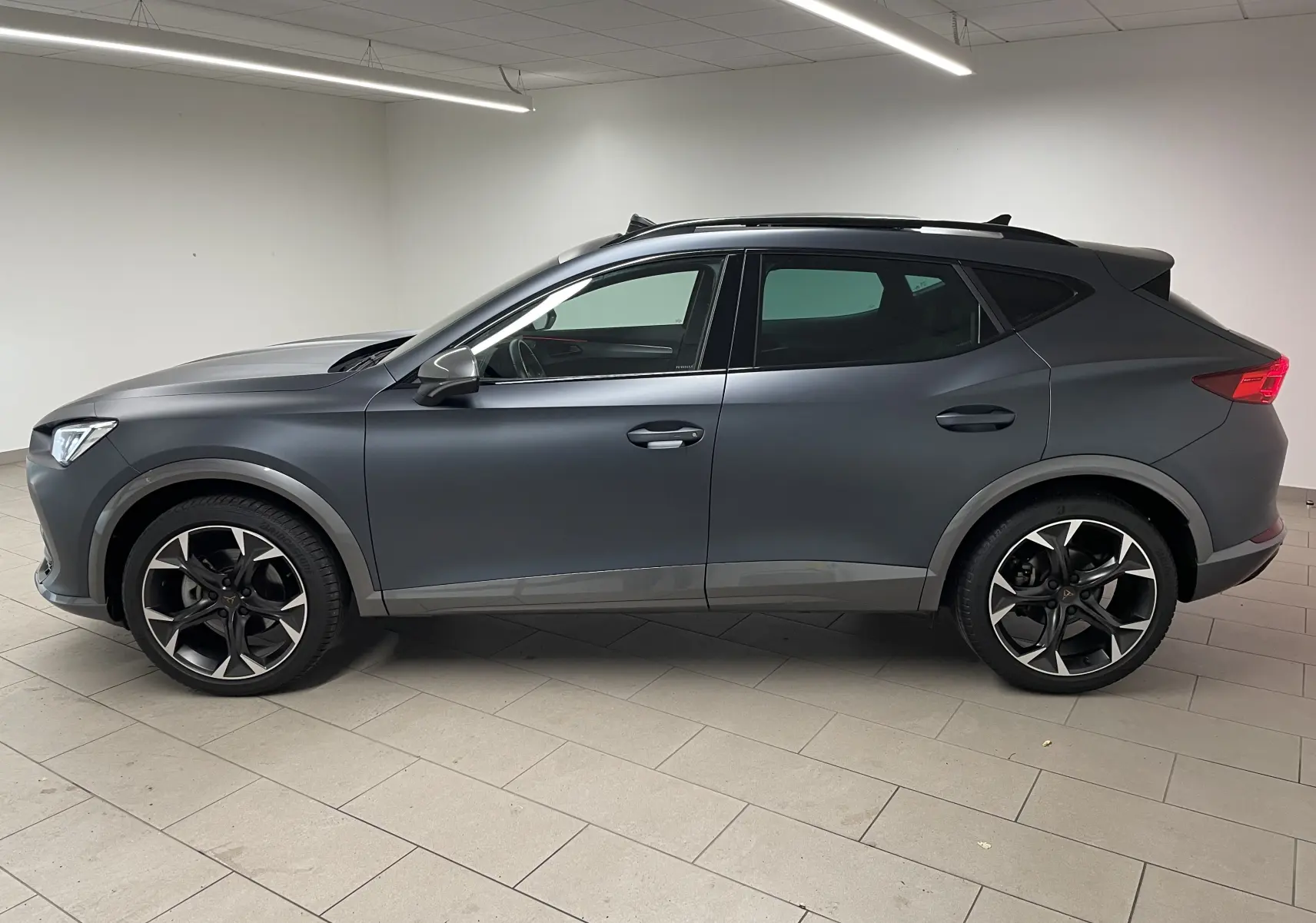 Profil côté gauche du CUPRA Formentor 1.5 TSI 150 DSG7 VZ-LINE 2023 en gris magnétique mat avec jantes sport noires.