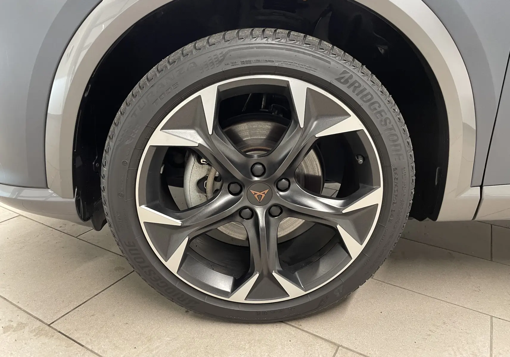 Gros plan sur la roue avant droite du CUPRA Formentor gris magnétique mat avec jante alliage noire et argentée distinctive.