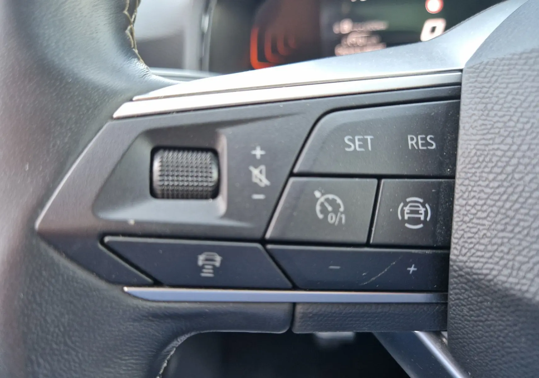 Gros plan sur les commandes de régulateur de vitesse et assistance au volant du volant d'une SEAT Arona 2025.