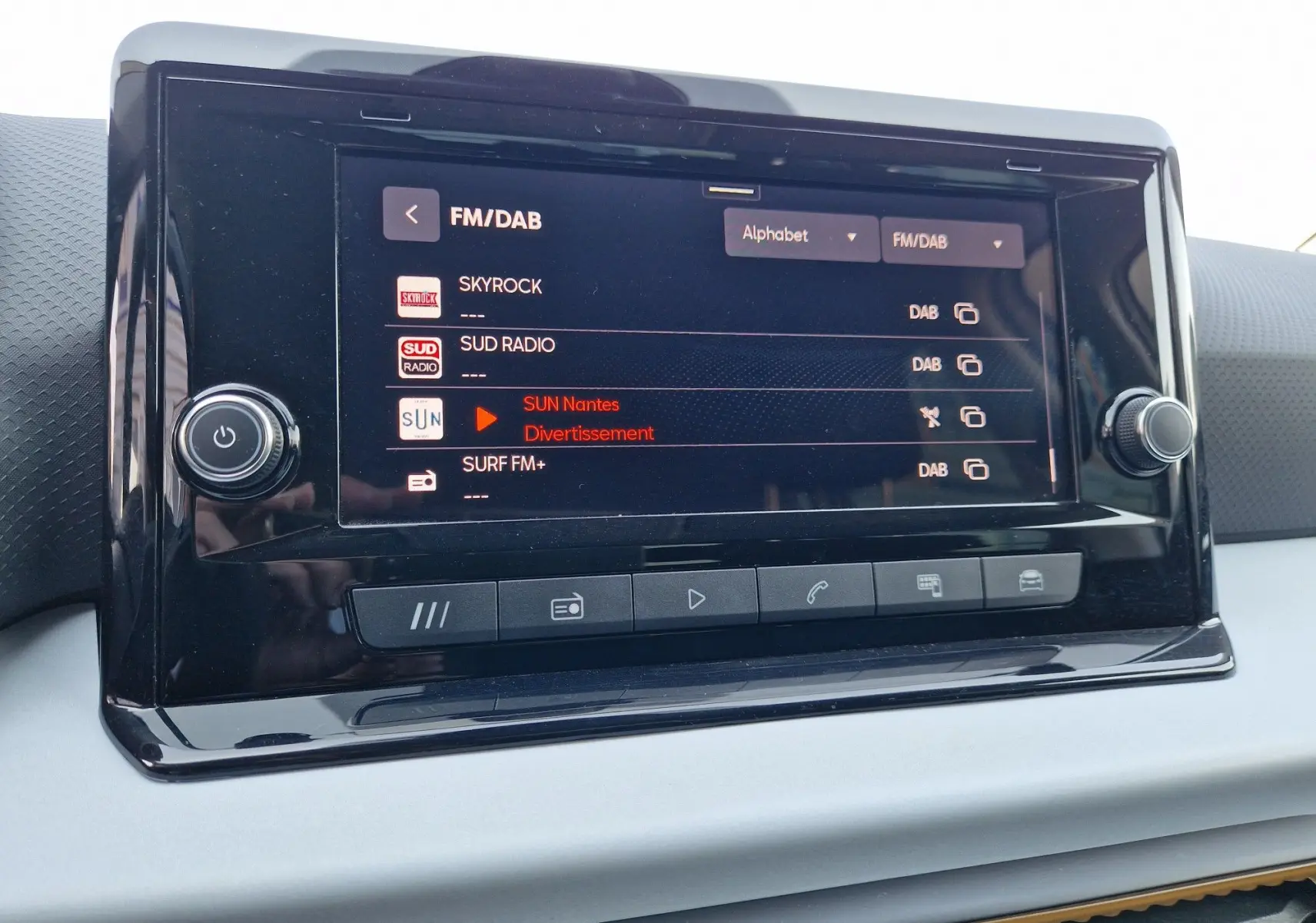 Écran tactile central du tableau de bord du SEAT Arona 2025, affichant les stations radio FM/DAB.