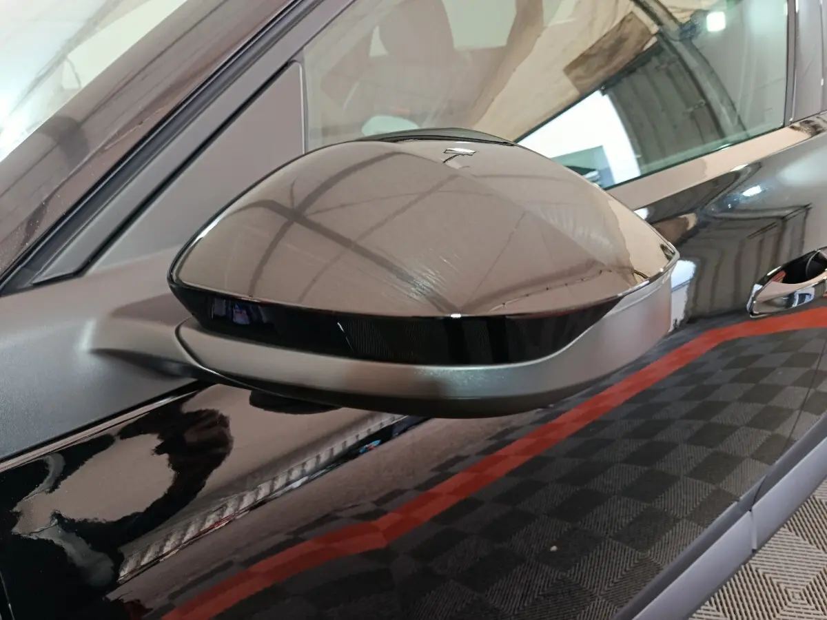 Rétroviseur côté gauche noir brillant du Citroën C5 Hybride 145ch auto MAX avec carrosserie noire réfléchissante.