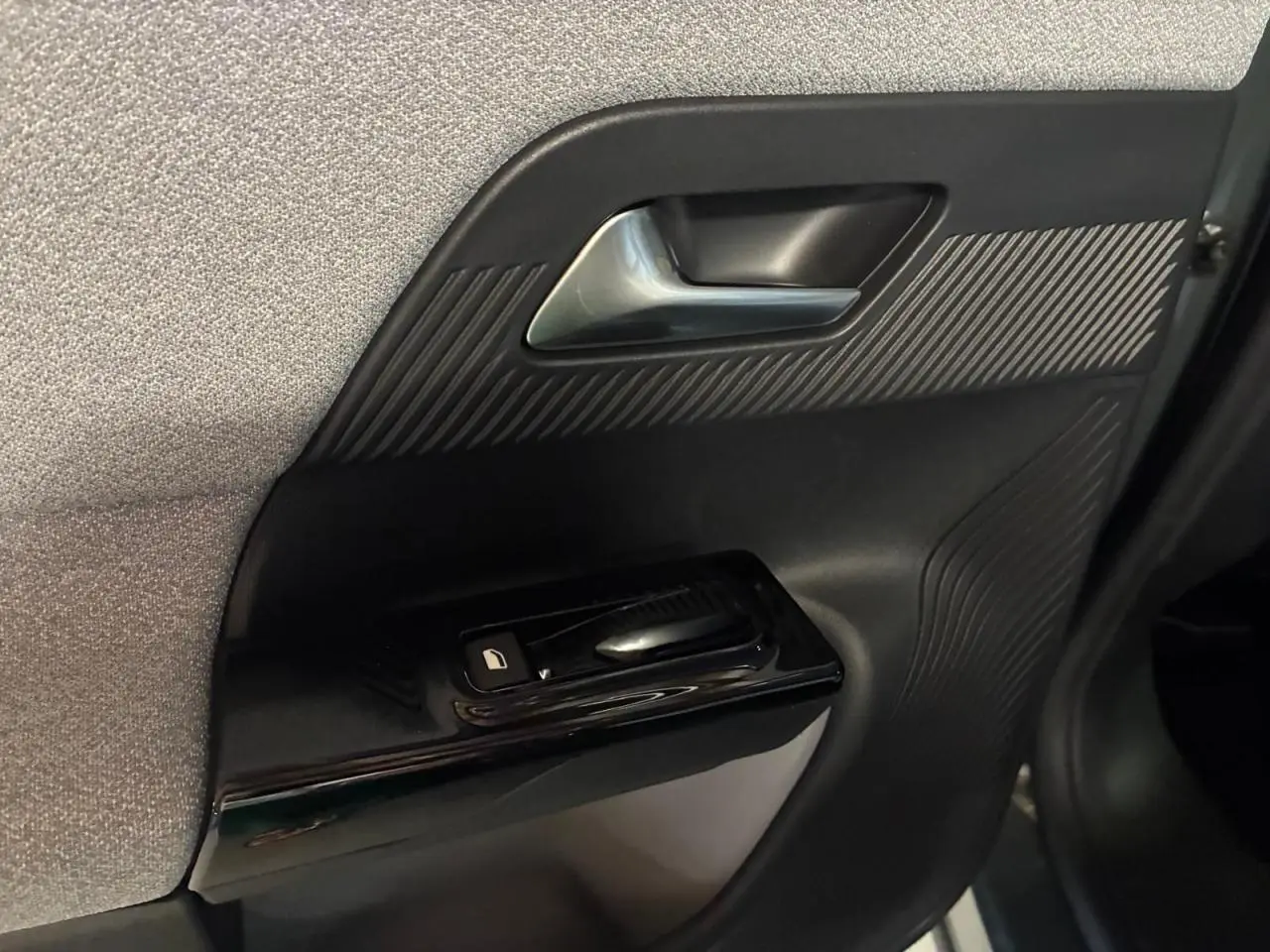Détail de la porte intérieure côté gauche du Citroën C5 Aircross II vert, avec poignée argentée et commande de vitre noire.