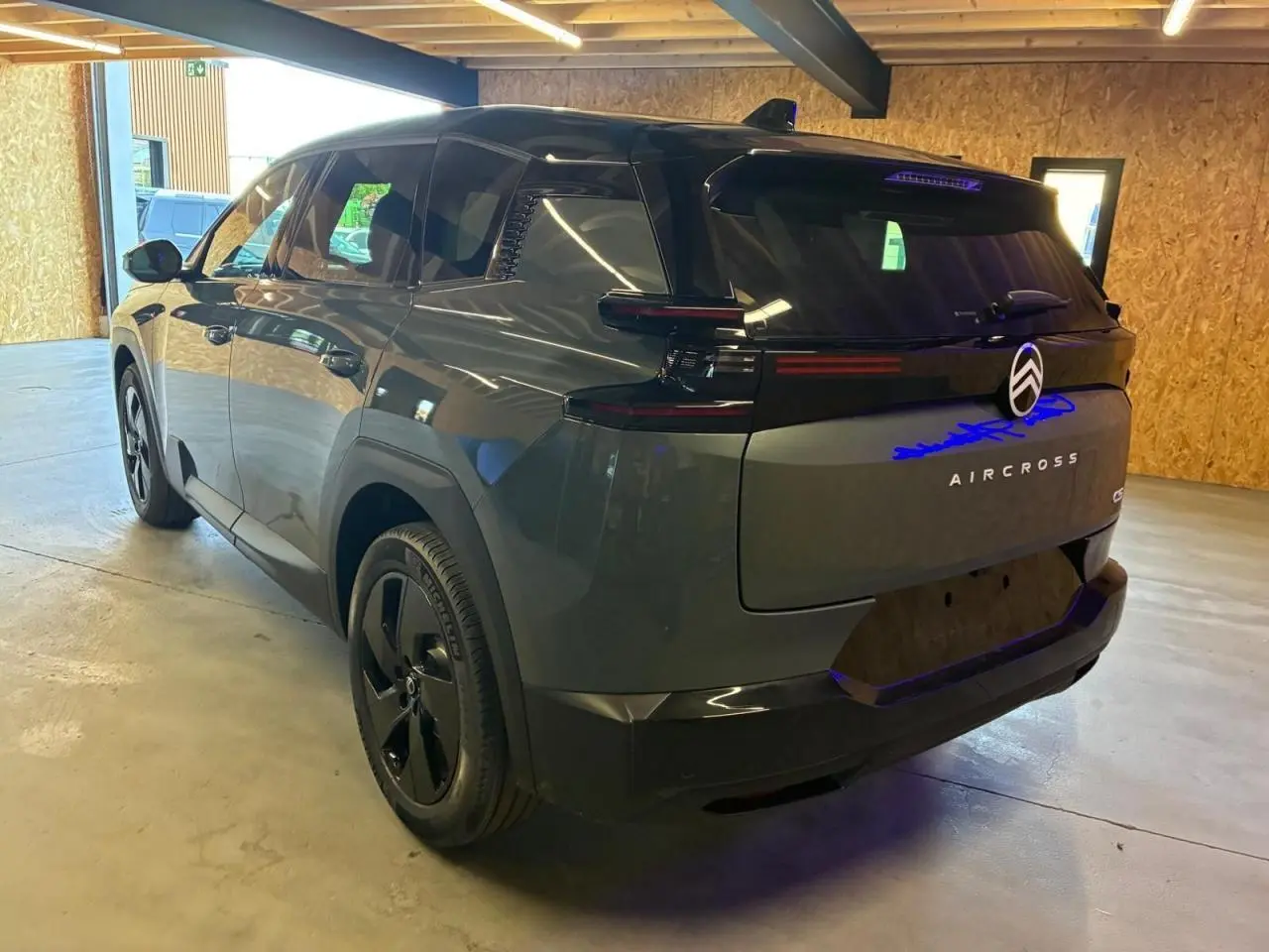 Vue 3/4 arrière droite du Citroën C5 Aircross 2026 vert, avec feux arrière noirs et jantes noires distinctives.