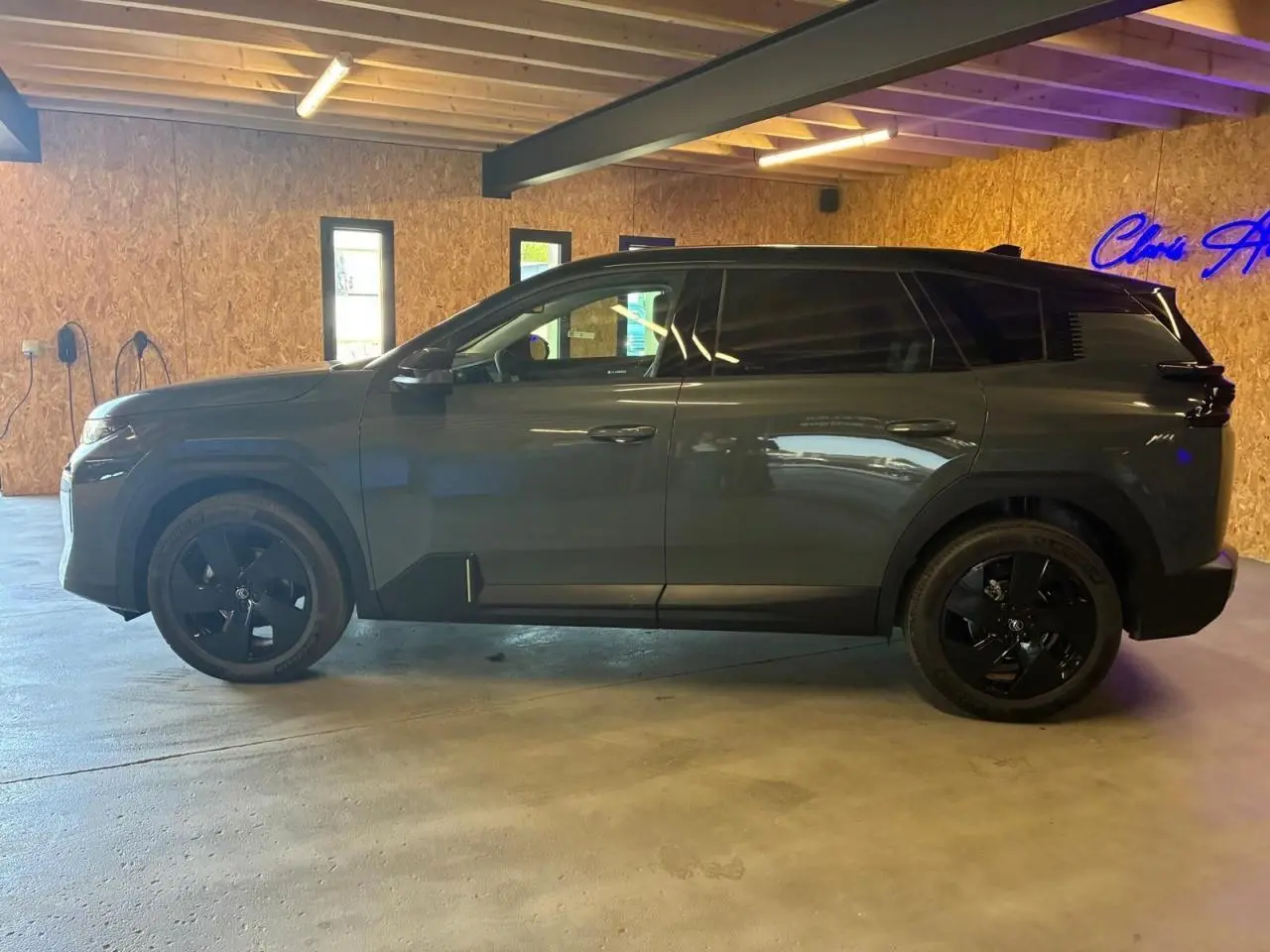 Vue latérale gauche du Citroën C5 Aircross 2026 vert, avec jantes noires et vitres teintées, en intérieur.