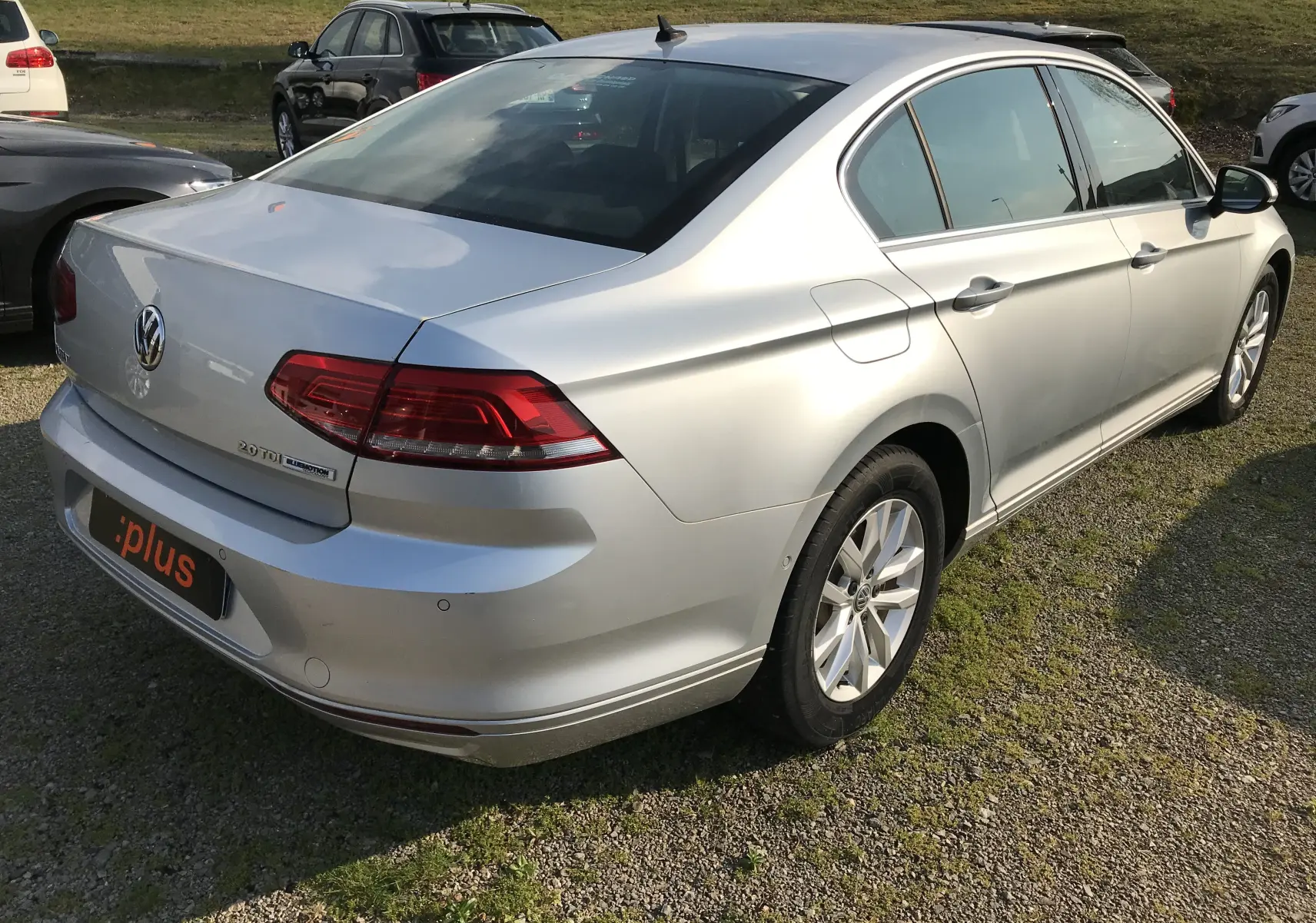Volkswagen Passat reflet d'argent vue 3/4 arrière droit, avec feux arrière LED et jantes alliage visibles.
