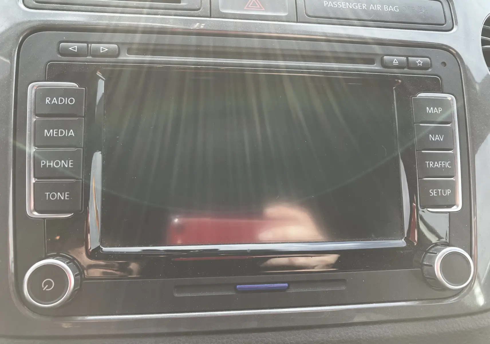 Écran tactile central du tableau de bord du Volkswagen Tiguan blanc 2013 avec commandes radio et navigation visibles.