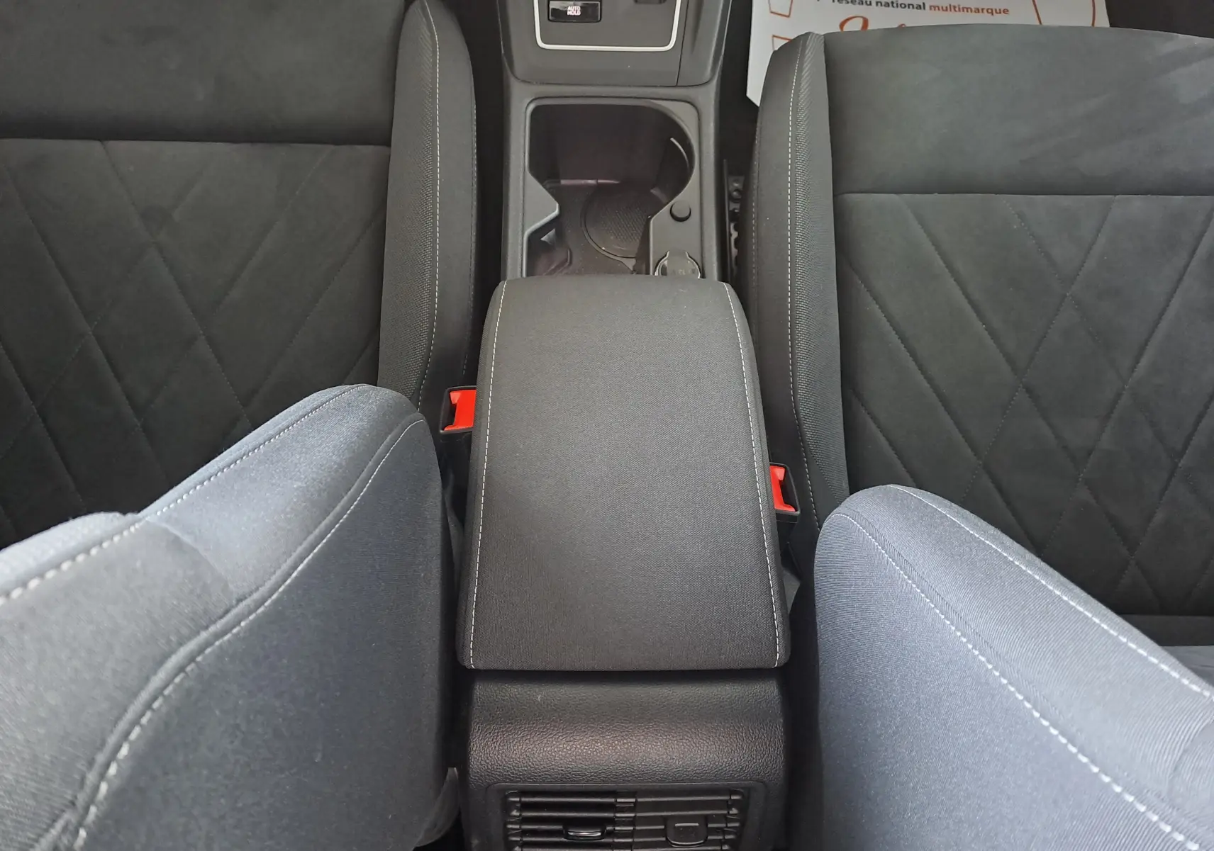 Vue plongeante sur l'accoudoir central et les sièges gris foncé de la Volkswagen Golf VIII 1.4 e-Hybrid 2021.