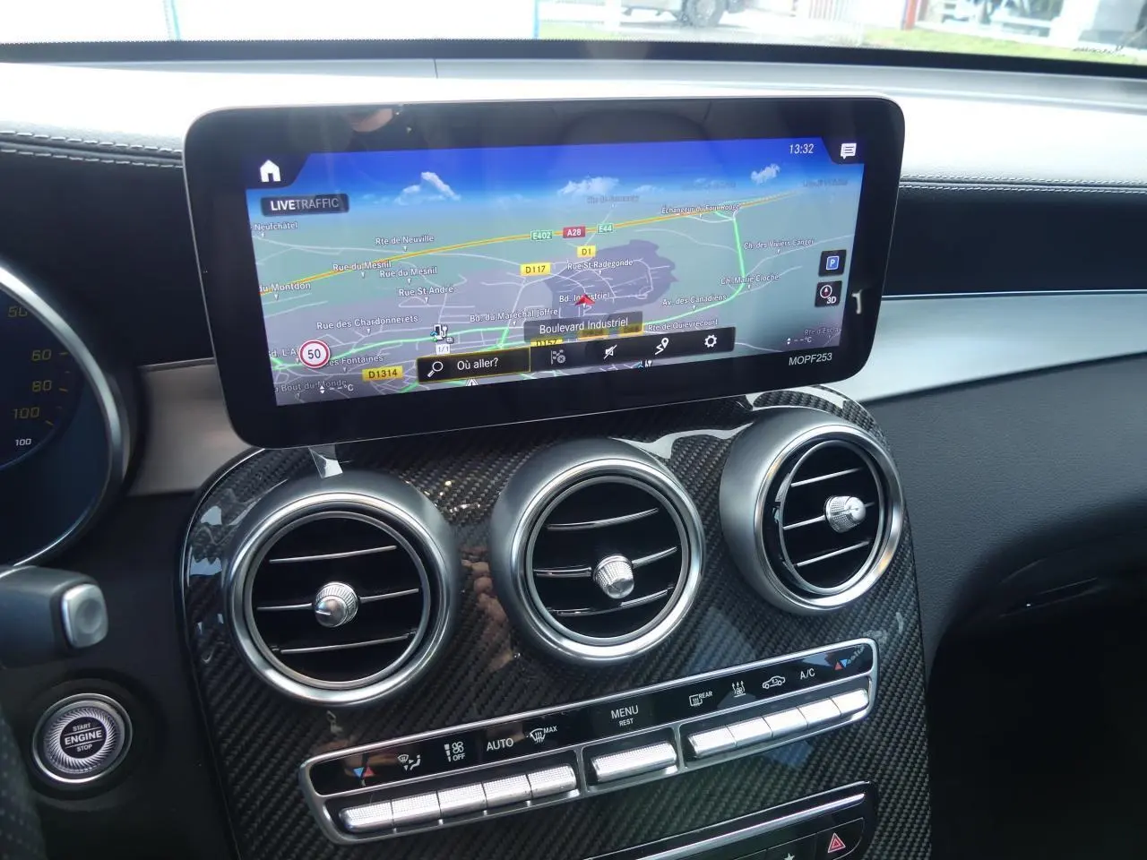 Détail du tableau de bord Mercedes GLC Coupé 300 hybride avec écran navigation et aérateurs ronds finition carbone