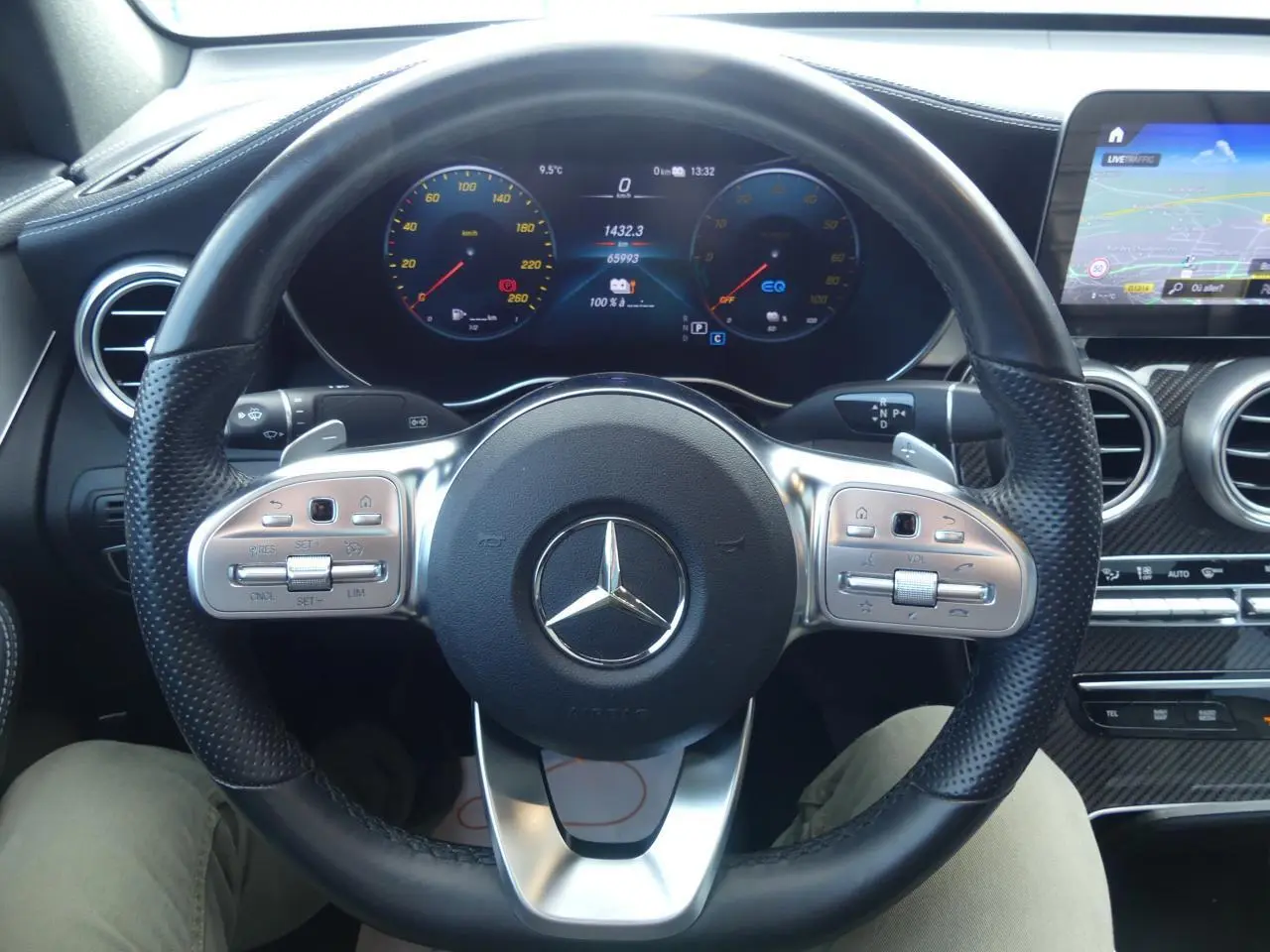 Volant sport en cuir noir avec commandes intégrées et tableau de bord digital d'une Mercedes GLC Coupé 300 hybride.