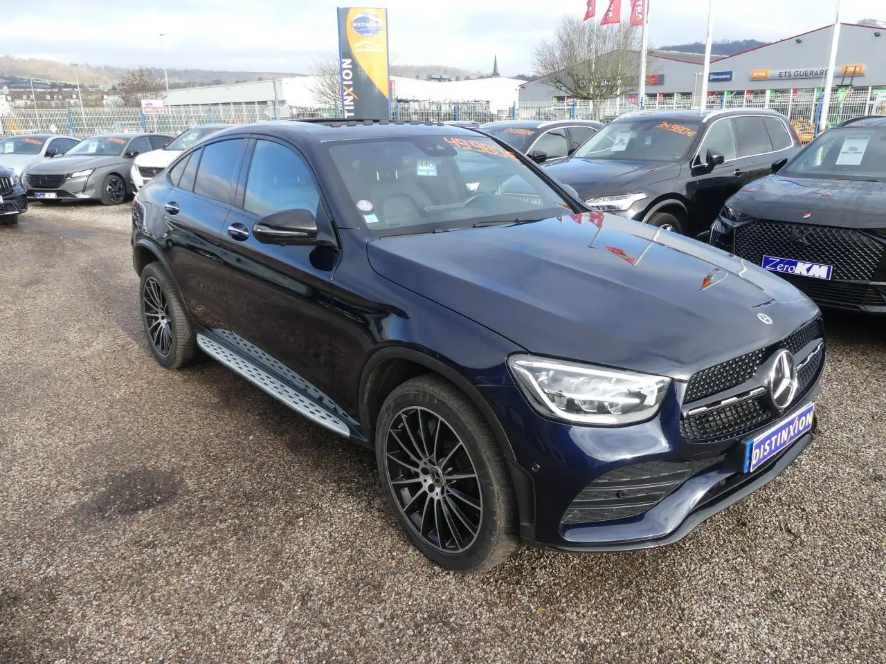 Mercedes GLC Coupé 300 hybride bleu foncé vue 3/4 avant droit avec jantes AMG noir brillant et marchepieds acier